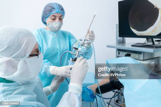 obstetrician, gynecologist, reproductologist works with a gyroscope. the nurse assists the surgeon during the hysteroscopy operation. - hysteroscope stock pictures, royalty-free photos & images
