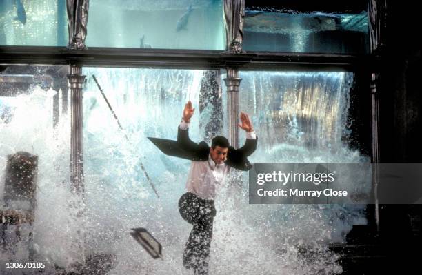 American actor Tom Cruise as Ethan Hunt, escaping through the collapsing aquarium in a restaurant, in a scene from the film 'Mission: Impossible',...