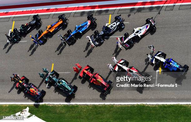 The F1 drivers stand on the grid with their cars during Day One of F1 Testing at Bahrain International Circuit on March 12, 2021 in Bahrain, Bahrain.