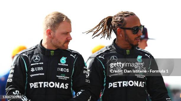 Valtteri Bottas of Finland and Mercedes GP and teammate Lewis Hamilton of Great Britain and Mercedes GP look on from the grid during Day One of F1...