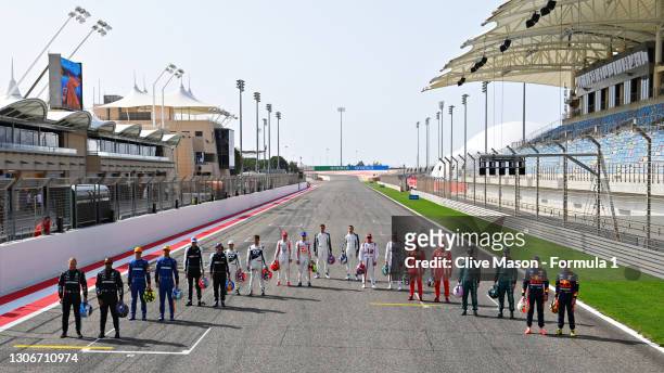 The F1 drivers stand on the grid during Day One of F1 Testing at Bahrain International Circuit on March 12, 2021 in Bahrain, Bahrain.