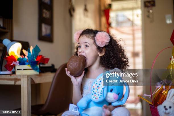 可愛的小孩女孩吃巧克力復活節彩蛋 - funny easter eggs 個照片及圖片檔