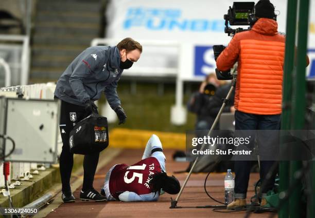 Bertrand Traore of Aston Villa receives medical attention after falling over the advertising boards during the Premier League match between Newcastle...