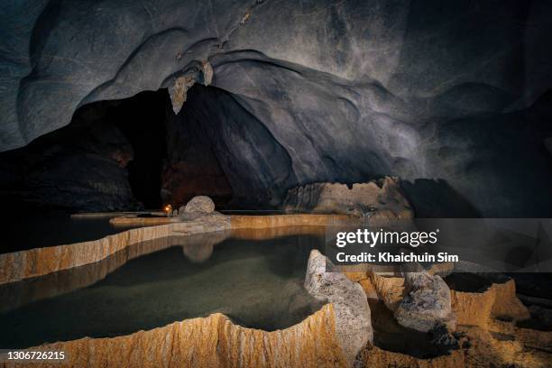 reflection of shallow pond inside a massive cave - stalactite stock pictures, royalty-free photos & images