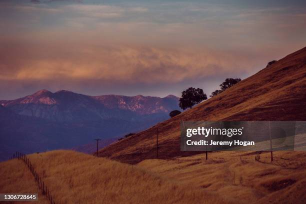 sun setting on high sierra nevada mountains beyond foothills near springville, california - springville california stock pictures, royalty-free photos & images