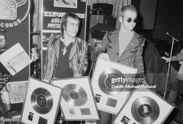 Elton John with his songwriting collaborator Bernie Taupin at a ceremony to award them gold discs for four of their co-written albums, 26th April...