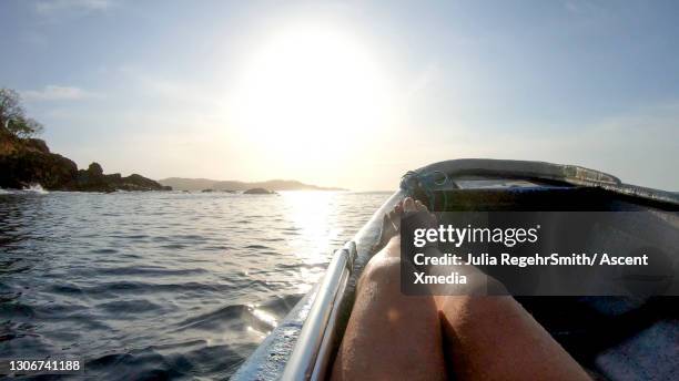 man drives motorboat out to sea in early morning - los santos inocentes fotografías e imágenes de stock