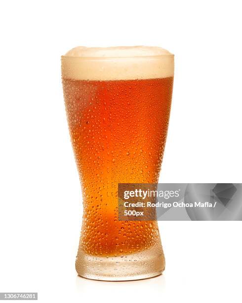 close-up of beer glass against white background - beer white background stock-fotos und bilder