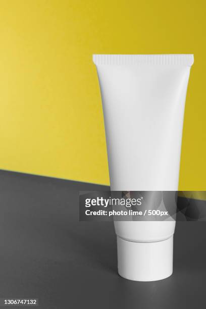 close-up of white paper against yellow background - shampoo bottle white background stock pictures, royalty-free photos & images