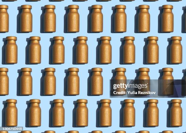 gold colored vaccine vials on the blue background - cologne bottle stock pictures, royalty-free photos & images