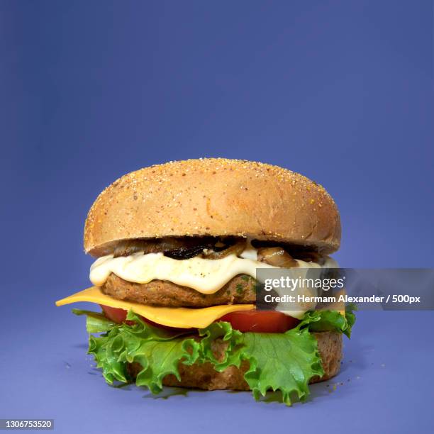 close-up of burger against blue background,centro,brazil - centro staples stock-fotos und bilder