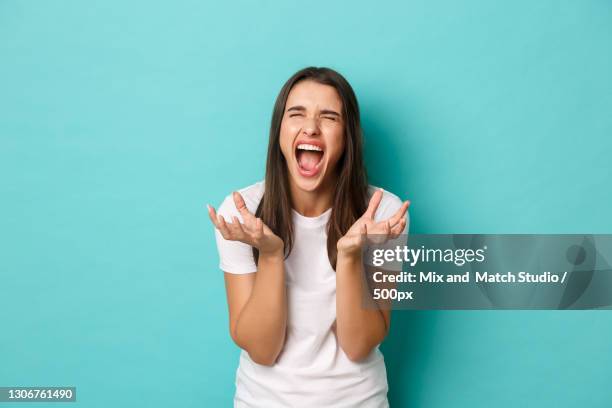 portrait of shocked woman against blue background - tensed idaho stockfoto's en -beelden