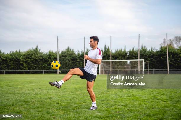 futbolista masculino maduro practica malabares para el control de balón - man playing ball fotografías e imágenes de stock