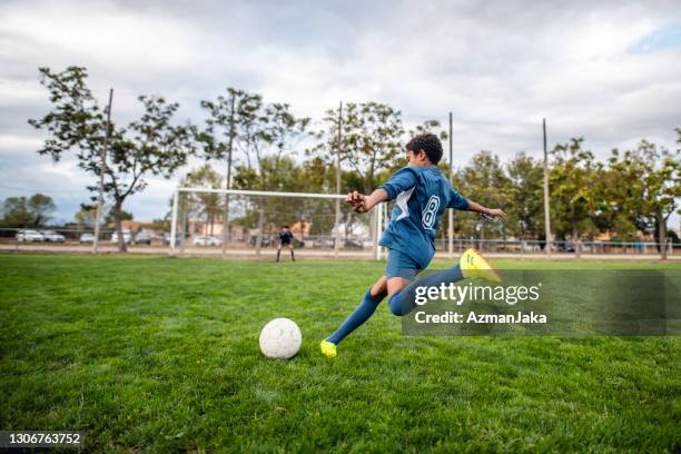 athletic mixed race boy footballer si avvicina palla per calcio - porta calcio foto e immagini stock