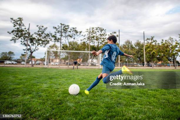 atletische mixed race boy voetballer nadert bal voor kick - soccer stockfoto's en -beelden