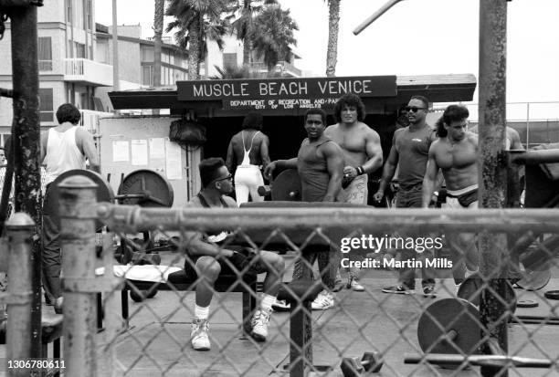 Group of men show off their muscles while working out at Muscle Beach in the Venice weight pen circa 1988 in Venice, California.