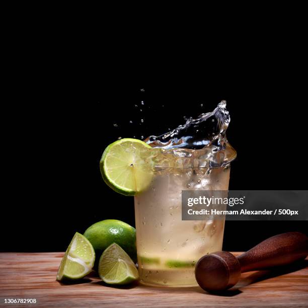 close-up of drink in glass on table against black background,centro,brazil - caipirinha foto e immagini stock