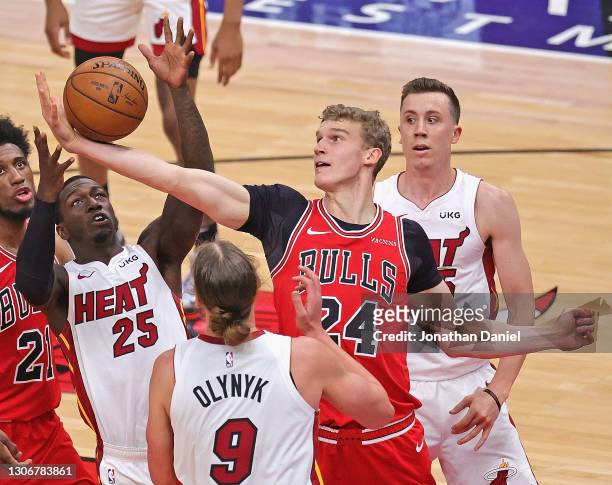 Lauri Markkanen of the Chicago Bulls grabs a rebound from Kendrick Nunn of the Miami Heat between Kelly Olynyk and Duncan Robinson at the United...