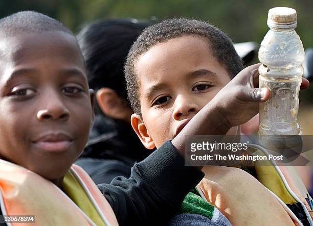 Haynes Public Charter students Delante Vaughn and Abdulrahim Robinson show off some trash they picked up while on a canoe trip on the Anacostia River...