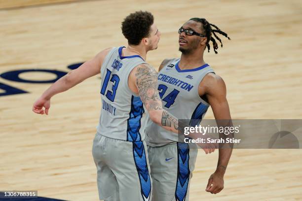 Christian Bishop celebrates with Denzel Mahoney of the Creighton Bluejays after their team's win in the second half against the Connecticut Huskies...