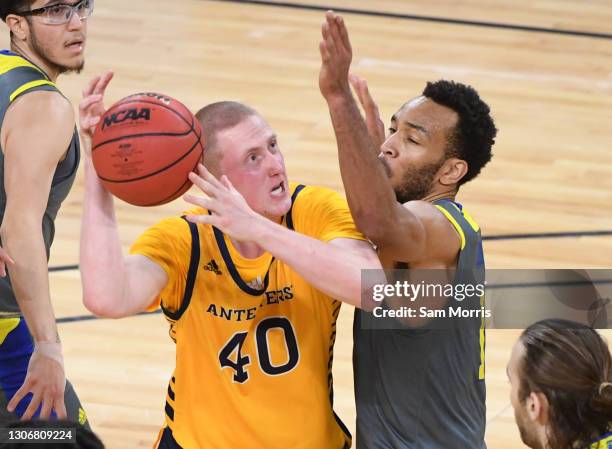 Collin Welp of the UC Irvine Anteaters is defended by Arinze Chidom of the UC Riverside Highlanders during their Big West Basketball tournament...