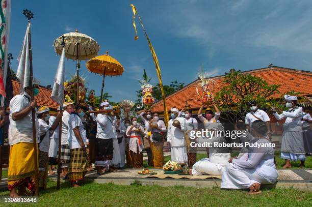 Balinese Hindu devotees pray during the Melasti ritual at Segara Temple on March 13, 2021 in Surabaya, Indonesia. The Melasti ritual is held annually...