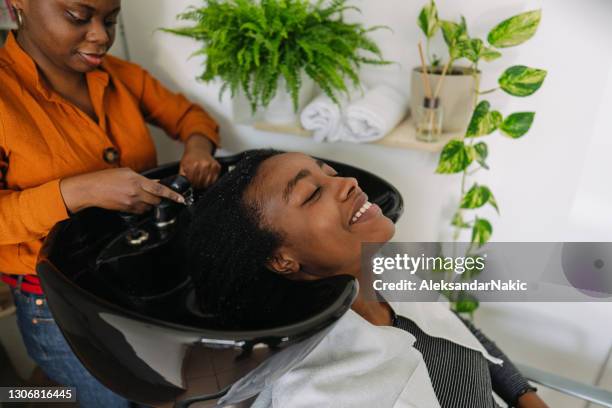 washing hair in a hair salon - women washing hair stock pictures, royalty-free photos & images