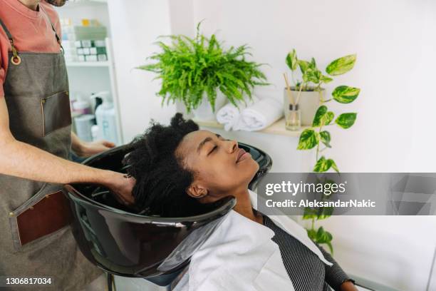 washing hair in a hair salon - washing curly hair stock pictures, royalty-free photos & images