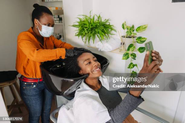 het bezoeken van kapsalon tijdens pandemie - hairdressers black woman stockfoto's en -beelden