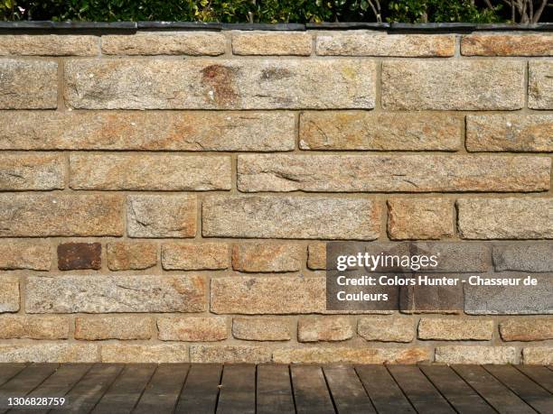 outdoor terrace with stone wall, wooden floor and plants in france - muro di pietra foto e immagini stock