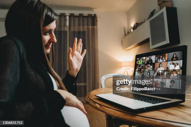 de zwangere vrouw heeft een videogesprek van huis met vele mensen - pregnant women greeting stockfoto's en -beelden