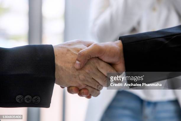 business successful concept: two businessmen shaking hand after success the business together - politik stock-fotos und bilder