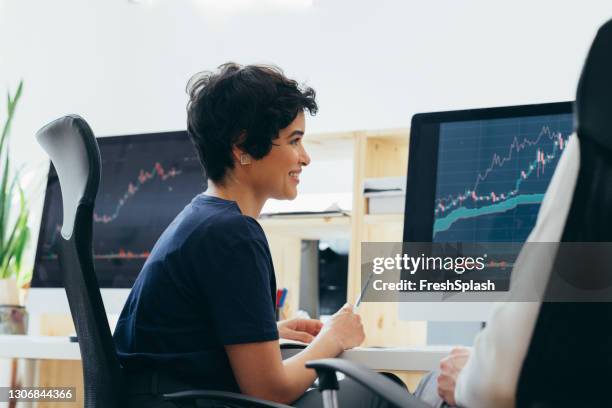 vista lateral de una empresaria feliz analizando gráficos en su oficina - mujer feliz sola 30 35 fotografías e imágenes de stock