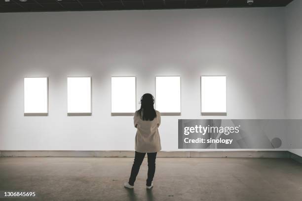 asian girl watching painting in art gallery - art gallery people fotografías e imágenes de stock