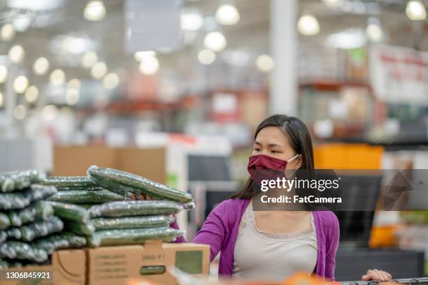 aziatische vrouw die komkommers bij de kruidenierswinkel koopt - large cucumber stockfoto's en -beelden