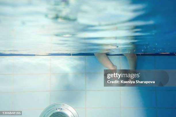 baby feet underwater in pool - stock photo - girl diving stockfoto's en -beelden