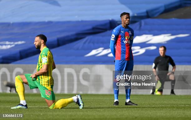 Wilfried Zaha of Crystal Palace stands at kick off as Matt Phillips of West Bromwich Albion takes a knee in support of the Black Lives Matter...