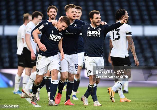 Shaun Hutchinson of Millwall FC celebrates with teammates Alex Pearce and Mason Bennett after scoring their team's first goal during the Sky Bet...