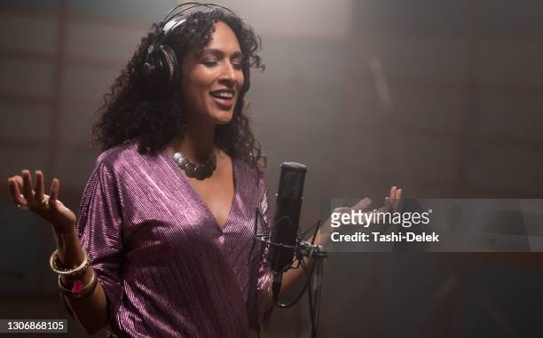 female singer singing into microphone in recording studio - lyric stock pictures, royalty-free photos & images