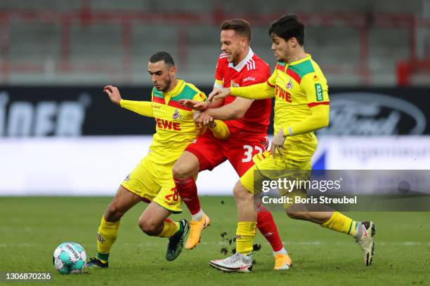 Marcus Ingvartsen of 1. FC Union Berlin is challenged by Ellyes Skhiri of 1. FC Koeln and Jorge Mere of 1. FC Koeln during the Bundesliga match...