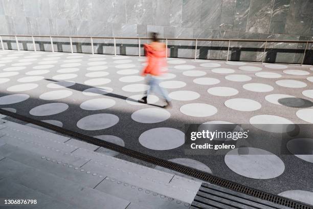 bewegung verschwommene person geht auf weiß gefleckten stadtplatz - fashion architecture stock-fotos und bilder