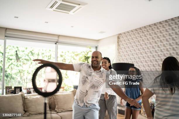 familia feliz filmándose bailando en casa - papa niña baile fotografías e imágenes de stock