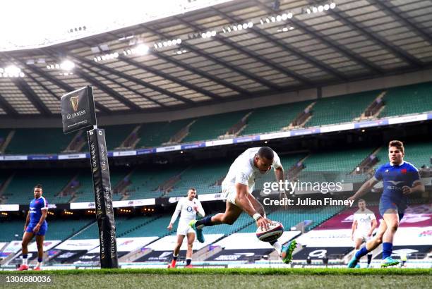 Anthony Watson of England touches down to score their side's first try under pressure from Antoine Dupont of France during the Guinness Six Nations...