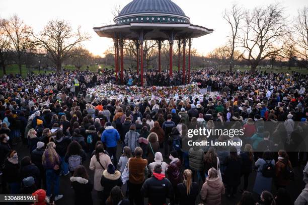 People gather to lay flowers and pay their respects at a vigil on Clapham Common, where floral tributes have been placed for Sarah Everard on March...