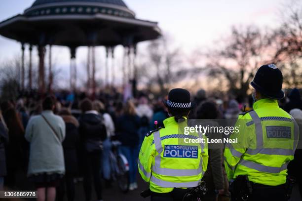 People gather to lay flowers and pay their respects at a vigil on Clapham Common, where floral tributes have been placed for Sarah Everard on March...