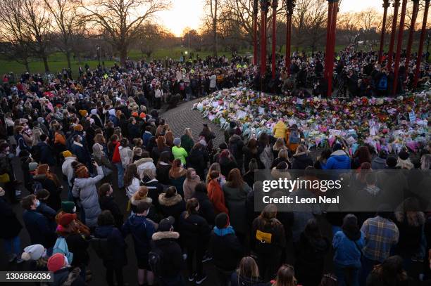 People gather to lay flowers and pay their respects at a vigil on Clapham Common, where floral tributes have been placed for Sarah Everard on March...