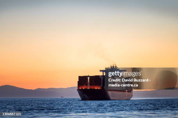 a container ships sails into the port of vancouver from english bay. - containerschip stockfoto's en -beelden