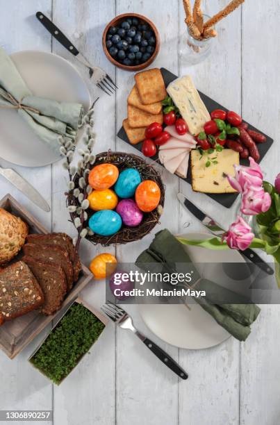 breakfast table for easter sunday celebration with colorful eggs and charcuterie - easter breakfast stock pictures, royalty-free photos & images