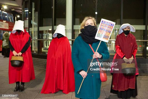 Labour MP for Walthamstow Stella Creasy supports Reclaim These Streets Vigil as she poses with protesters dressed as Handmaidens in red cloaks and...