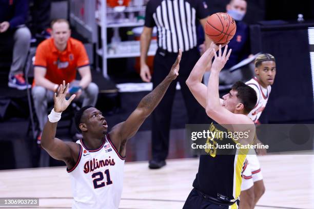 Luka Garza of the Iowa Hawkeyes shoots the ball over Kofi Cockburn of the Illinois Fighting Illini during the first half of the Big Ten men's...